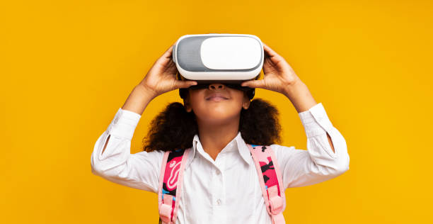 istock Black Girl In Virtual Reality Headset Standing Over Yellow Background 2186894931