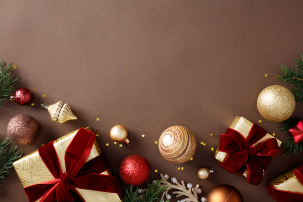 istock Flat lay composition with christmas gift boxes, ornaments, golden stars, pine branches on brown background 2186900373