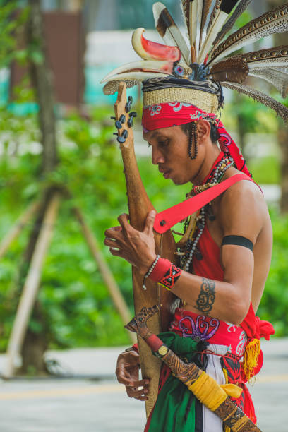 IKN, Indonesia - November 24th, 2024. He wears the traditional dayak clothing with mandau on his hip and a hornbill bird headwear.