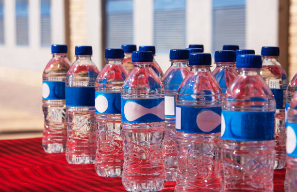 several bottles of bottled still water on a table, arranged in symmetry