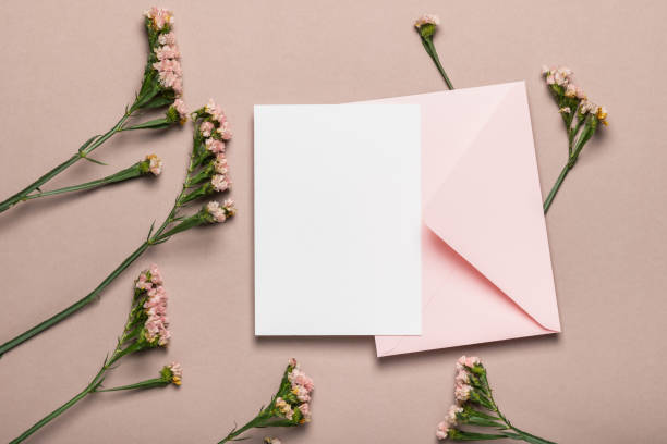 istock Pink envelope and blank form with flowers on a brown background. Greeting card, mockup. 2186909734