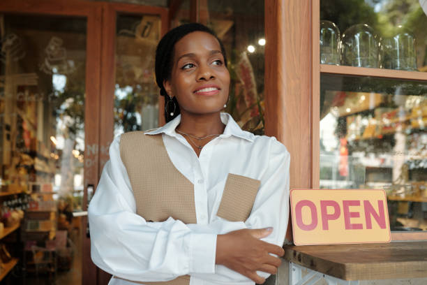 istock Smiling Shop Owner Standing by Open Sign Outside Storefront 2186911959