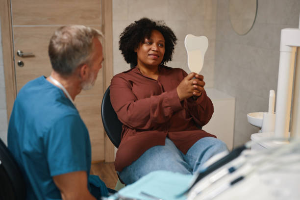 istock Smiling Patient Holding Mirror during Dental Checkup 2186914886