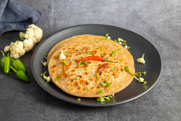 istock Gobi paratha is a popular Indian flatbread stuffed with spiced cauliflower, served warm with yogurt, pickles, or chutney. 2186915410