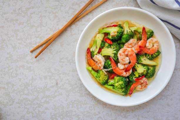 istock Homemade Stir fried broccoli with shrimp in a white ceramic plate  on cement background 2186918069