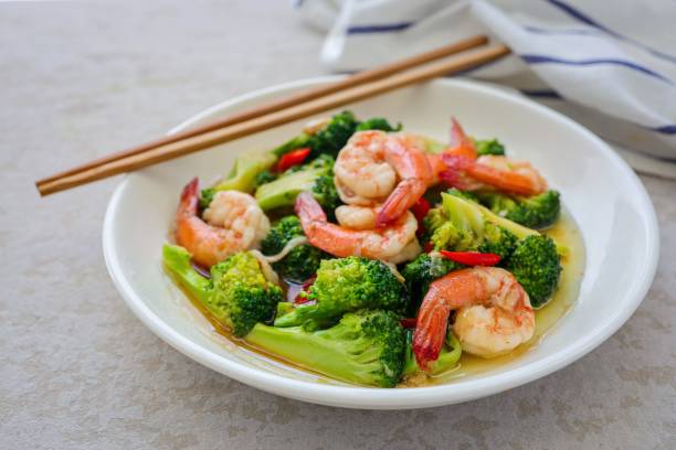 istock Homemade Stir fried broccoli with shrimp in a white ceramic plate  on cement background 2186918072