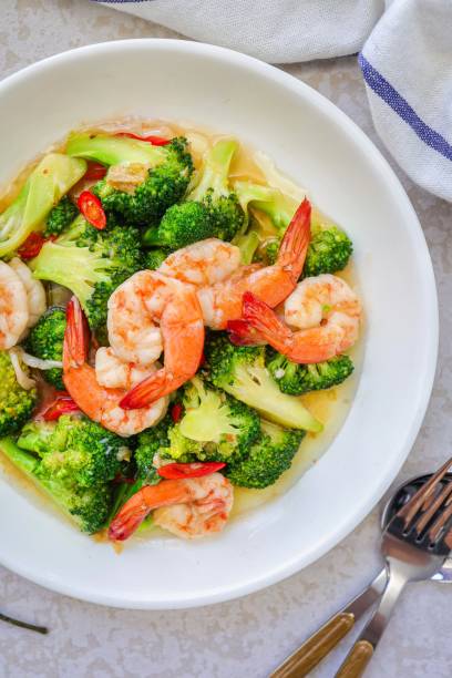 istock Homemade Stir fried broccoli with shrimp in a white ceramic plate  on cement background 2186918078