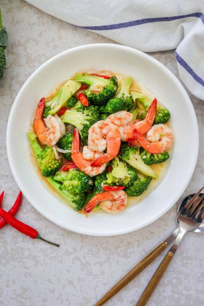 istock Homemade Stir fried broccoli with shrimp in a white ceramic plate  on cement background 2186918084