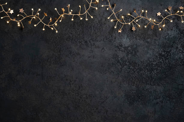 istock Holiday lights decorative garland hanging on dark textured background 2186918190