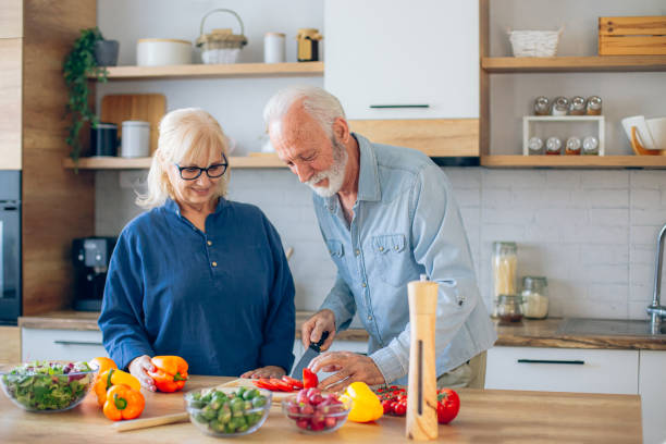 istock Senior couple spending time together while cutting vegetables at kitchen 2186922465