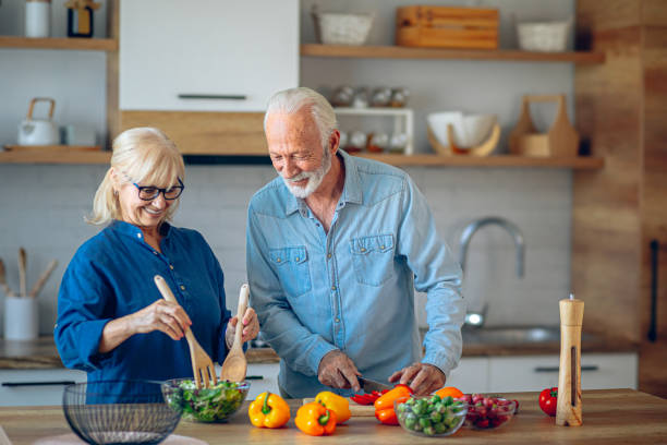 istock Senior couple spending time together while cutting vegetables at kitchen 2186923032