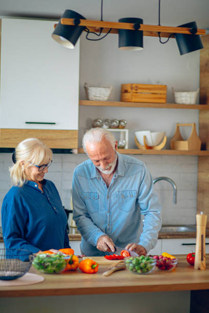 istock Senior couple spending time together while cutting vegetables at kitchen 2186923206