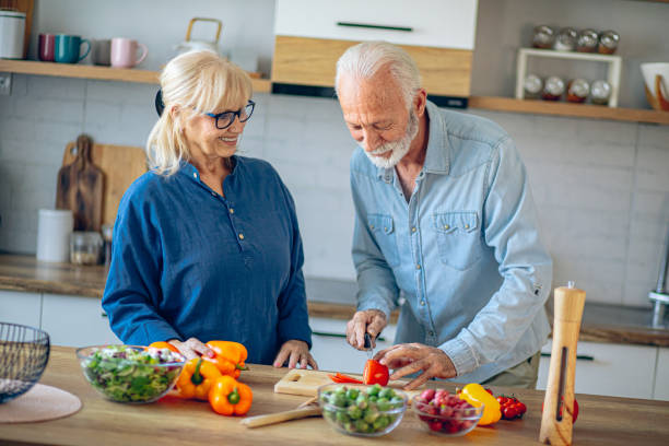 istock Senior couple spending time together while cutting vegetables at kitchen 2186923400