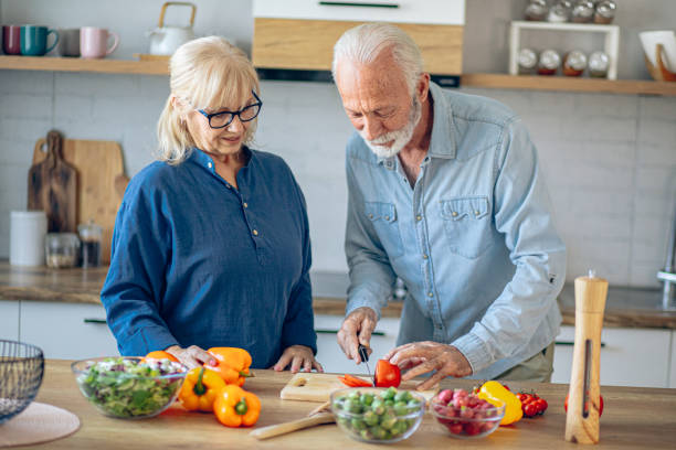 istock Senior couple spending time together while cutting vegetables at kitchen 2186923745