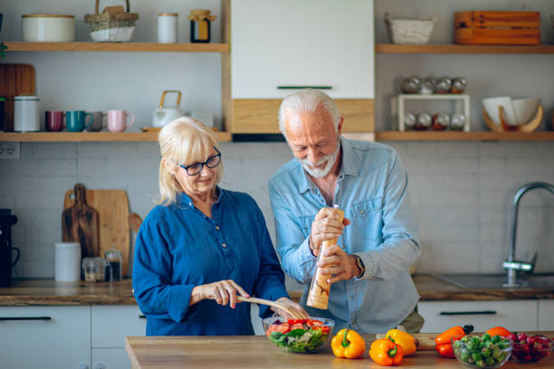istock Senior couple having fun while cooking lunch 2186923775