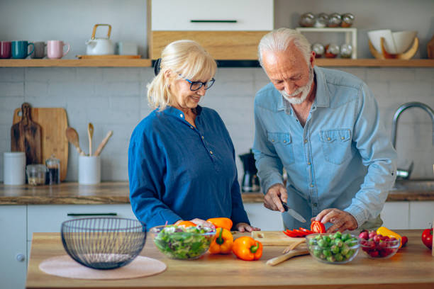 istock Senior couple spending time together while cutting vegetables at kitchen 2186923828