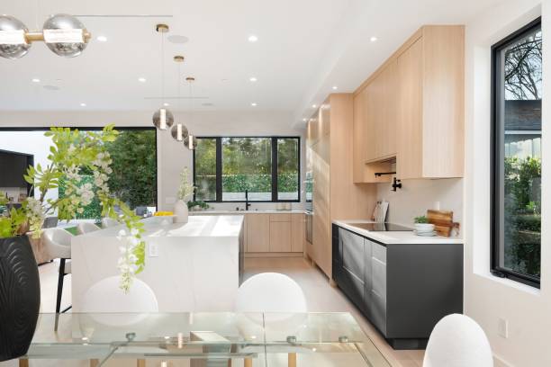 istock Modern kitchen with light wood cabinets and large windows. 2186926434