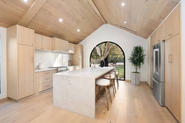 istock Modern kitchen with light wood cabinetry and garden view. 2186926576