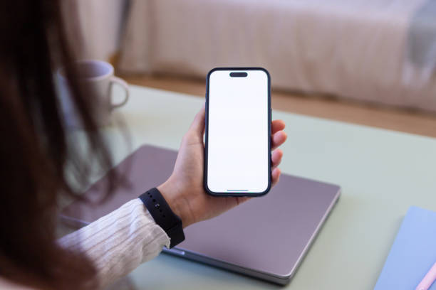 istock Woman holding smartphone with blank screen in home office 2186928030