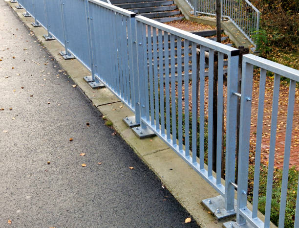 istock bridge railing with vertical fence posts anchored into the ground with four concrete screws. the railing is fixed from the side of the bridge into the concrete. 2186928931