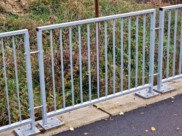 istock bridge railing with vertical fence posts anchored into the ground with four concrete screws. the railing is fixed from the side of the bridge into the concrete. 2186929030