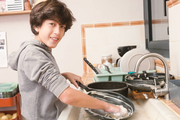istock A young boy is washing a pan in the kitchen 2186929033