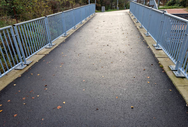 istock bridge railing with vertical fence posts anchored into the ground with four concrete screws. the railing is fixed from the side of the bridge into the concrete. 2186929142