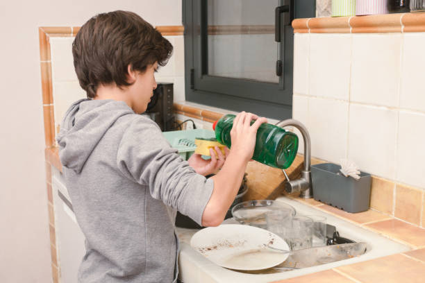istock A boy is washing dishes in a kitchen 2186929298