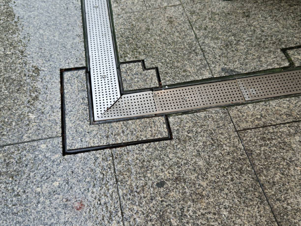 istock across the path there is a channel with a metal grid for drainage interlocking paving. the water is drained from the surface into the gutter and further into the rain sewer 2186929756