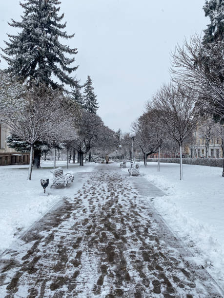 istock Winter Promenade with Footprints and Snowy Benches 2186933311