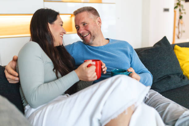 istock Cheerful Couple Relaxing on Sofa with Coffee Mugs 2186934522