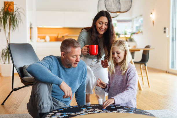 istock Family Completing Puzzle Together in Cozy Home Interior 2186934623