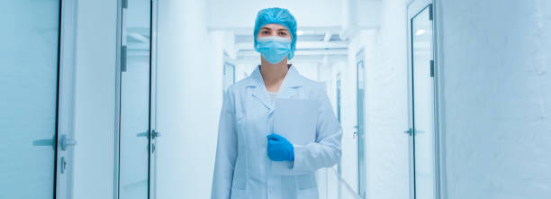 istock Woman in protective medical wear going through empty laboratory corridor 2186935482
