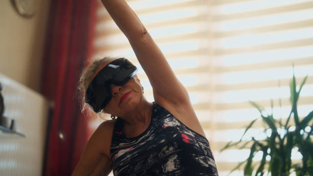 istock Active senior sports woman exercising while using vr glasses at home 2186939169