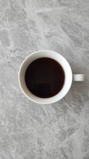 istock White mug of black coffee on a gray background, top view. 2186939197