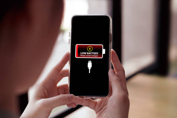 Women use mobile phones with a low battery notification screen