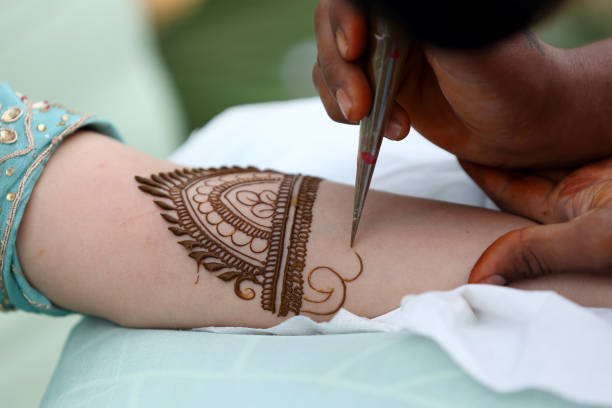 istock An artist applying intricate henna. 2186942357