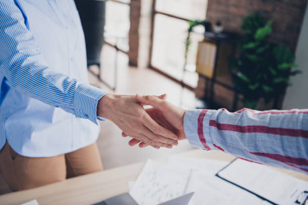 istock Two professionals shake hands in a modern office, creating a harmonious business connection that symbolizes agreement and partnership. 2186944667
