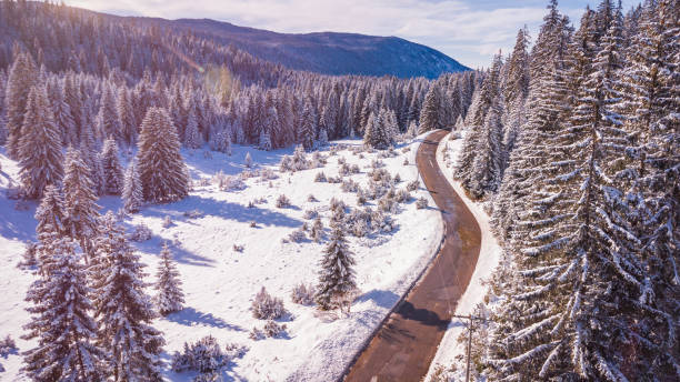 istock Scenic Winter Road Through Snowy Forest in Mountain Landscape 2186949221