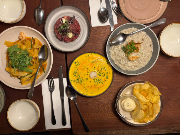istock Dinner Table with Scallop Pumpkin Soup, Steak Tartare, Risotto and Chips. bird's eye view 2186952630