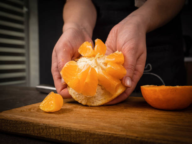 istock Slicing orange on a wooden board 2186952735