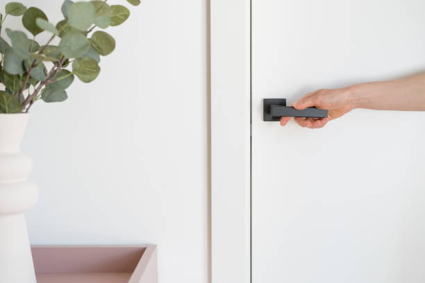 istock Hand reaching for a modern door handle in a stylish living room setting 2186952936