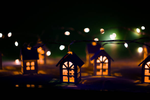 Christmas garland. Wooden houses. Bright lights. Cozy mood. Small lovely huts.