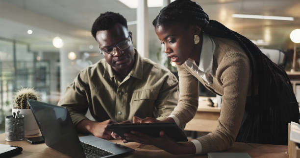 istock Business, black people or discussion in office with tablet for data analysis on website traffic for troubleshooting. Web analyst, team or employees monitor site performance to improve user experience 2186953820