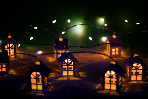 Colorful Christmas lights decorate a two-story house, yard and fence with a bright snowman and festive figures, creating a joyful holiday scene full of warmth and celebration.Brooklyn, NYC, USA