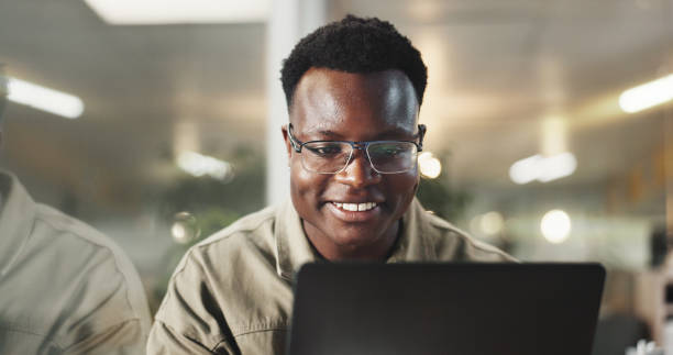 istock Black man, laptop and global communication in office, email client and online to update website. Male person, journalist and chat to contact for quote in workplace, glasses and reporter for article 2186954301