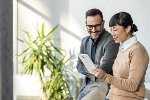 istock Team communication - Japanese woman and her colleague analyze data on a tablet 2186956073