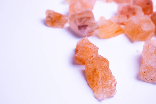 A pile of pink rocks on a white background. The rocks are of different sizes and shapes, and they appear to be arranged in a random pattern.