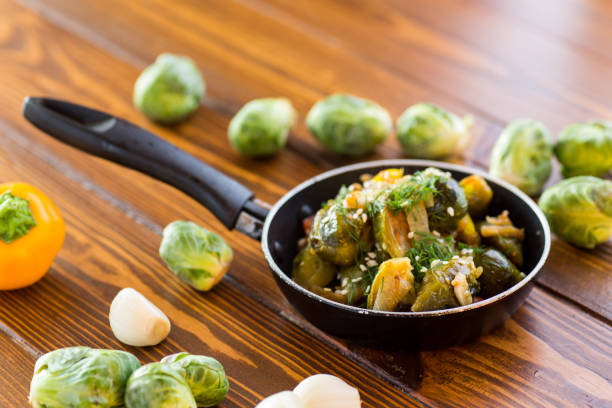 Brussel sprouts cooked with vegetables and spices, on a wooden table .