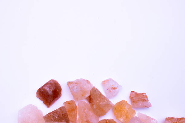 A pile of pink rocks on a white background. The rocks are of different sizes and shapes, and they appear to be arranged in a random pattern.
